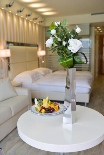 a table with a vase of flowers and a plate of fruit at Park Hotel Imperial in Limone sul Garda