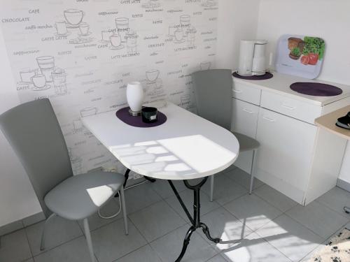 a white table and chairs in a kitchen with writing on the wall at An der Allee 7 App in Dahme