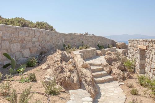 a stone wall with some stairs next to a wall at Bellevue Villas in Plaka