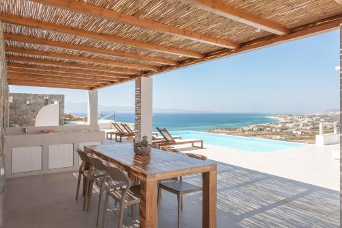 a dining room with a table and a view of the ocean at Bellevue Villas in Plaka