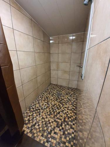 a bathroom with a shower with a tiled floor at Gorse Hill Glamping in Newcastle