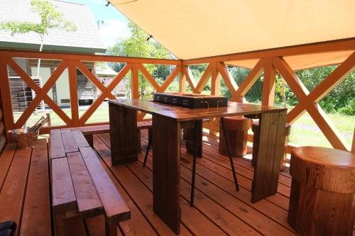 a wooden deck with a table on top of it at フォレストコテージ奥州 in Oshu