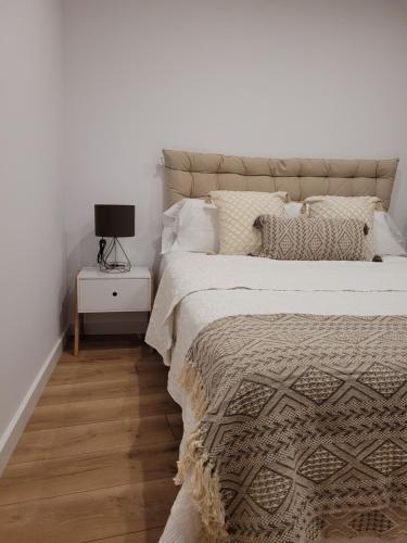 een slaapkamer met een bed en een nachtkastje met een lamp bij somtresapartament in Platja  d'Aro