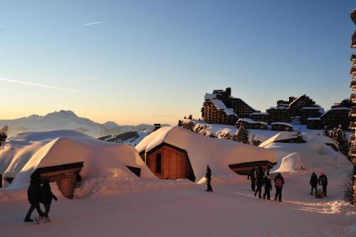 a group of people standing in the snow in front of buildings at Hôtel des Dromonts by SOWELL COLLECTION in Avoriaz