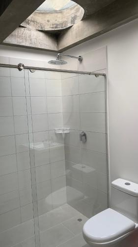 a bathroom with a glass shower with a toilet at Soy Local Primavera in Medellín