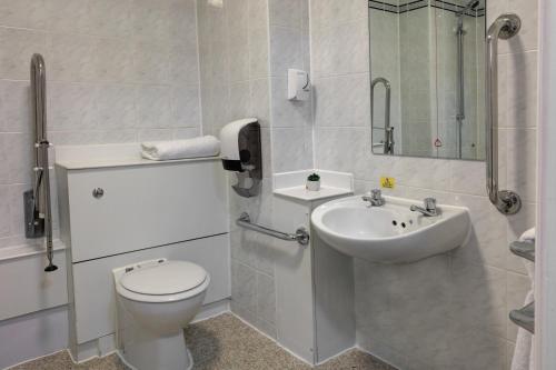 La salle de bains est pourvue de toilettes et d'un lavabo. dans l'établissement Orchid Epsom; Sure Hotel Collection by Best Western, à Epsom