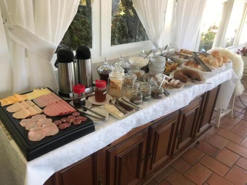 a buffet with a variety of meats and cheese at Pousada Chateau Colinas in Campos do Jordão