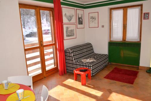 sala de estar con silla y mesa en House Nuova Nube by Holiday World, en Borgata Sestriere