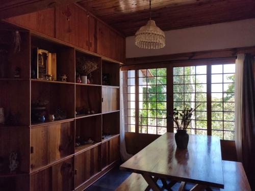 a dining room with a table and a large window at Casa com vista verde in Ouro Preto