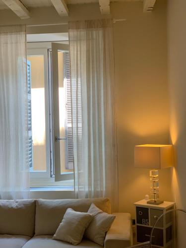 Fifty Eight Suite Milan Brera في ميلانو: غرفة معيشة مع أريكة ونافذة