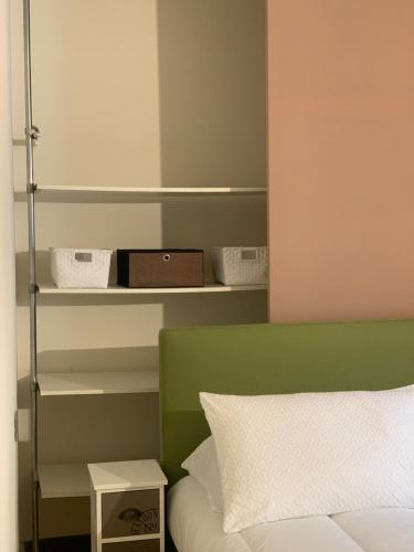 a bedroom with a green and white bed and shelves at Fifty Eight Suite Milan Brera in Milan