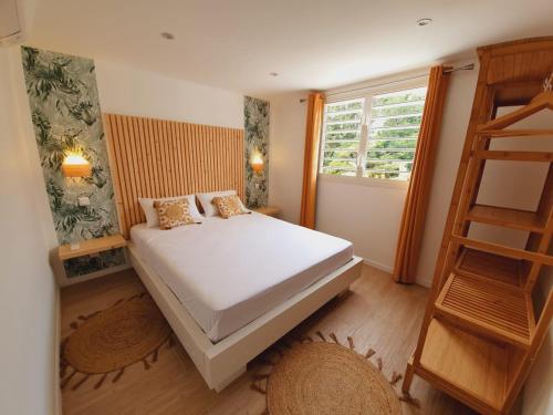 Habitación pequeña con cama y escalera en Kozycoco - Suite Kozy - séjour tropical au calme, en Schœlcher