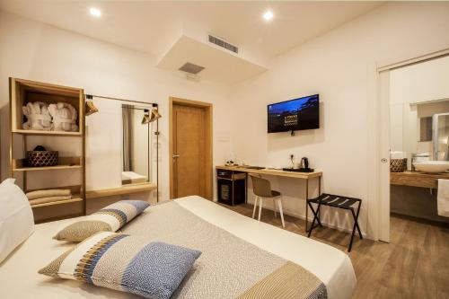 a bedroom with a bed and a desk and a bathroom at NOHA Lifestyle Hotel - Adults Only in Pula
