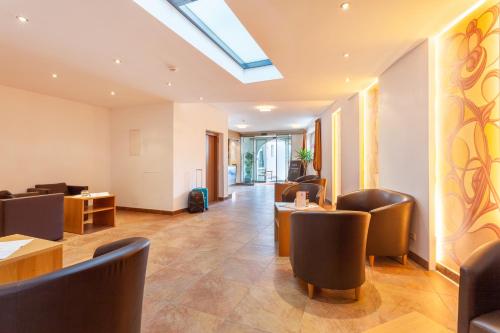 a restaurant with leather chairs and tables and a skylight at Apart-Hotel Alpinsonnenresidenz in Fiss