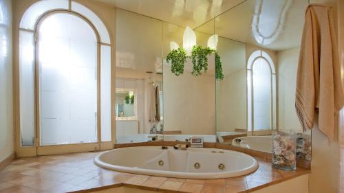 a large bathroom with a tub and a large mirror at Rental in Rome Trevi Fouintain View Apartment in Rome