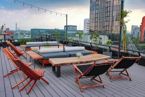 a patio with tables and chairs on a roof at Hotel Fontan Reforma Centro Historico in Mexico City