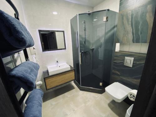een badkamer met een douche, een wastafel en een toilet bij Hotel Terrazzo in Starunya