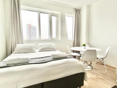 een slaapkamer met een bed en een tafel en stoelen bij City Home Finland Arena Suite - Perfect location with City View in Tampere