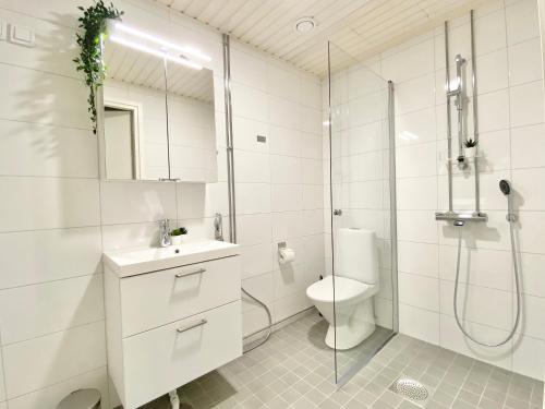 een witte badkamer met een douche en een toilet bij City Home Finland Arena Suite - Perfect location with City View in Tampere