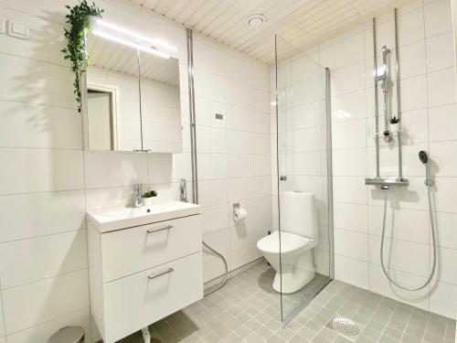 a white bathroom with a shower and a toilet at City Home Finland Arena Suite - Perfect location with City View in Tampere