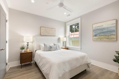 um quarto branco com uma cama e uma janela em The Ashley Suite at 122 Spring em Charleston