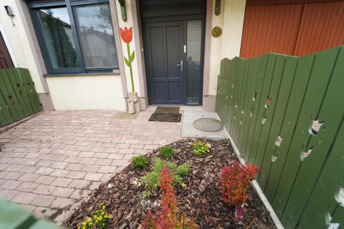 un jardín frente a una casa con puerta en Tulip Home Guest House, en Vác