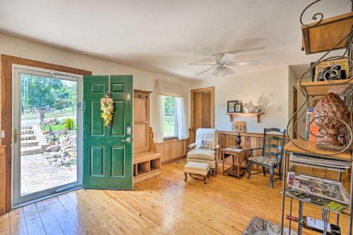 a living room with a green door and a table at Charming Cottage Less Than 10 Mi to Wineries and Skiing! in Nellysford
