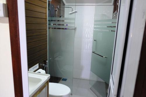 a bathroom with a toilet and a glass shower at D'Razna Chalet Pantai Seberang Takir in Kuala Terengganu