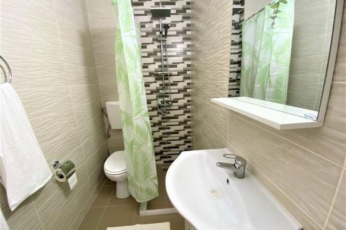 een badkamer met een wastafel, een toilet en een spiegel bij Perla Spacious 2 Bedroom Apartment in Boekarest