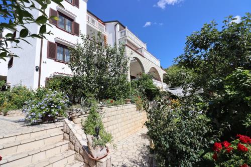 a building with flowers and plants in front of it at Villa Sojat in Crikvenica