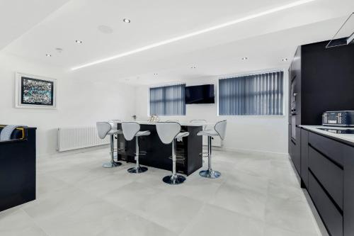 a kitchen with a bar with stools in it at Wellington Suites by Sasco Apartments in Blackpool