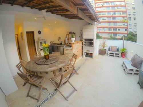 a patio with a wooden table and chairs on a balcony at Rede Reserva Copacabana in Rio de Janeiro