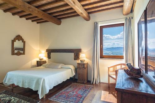 1 dormitorio con cama y ventana grande en Bibbianello, en Buonconvento