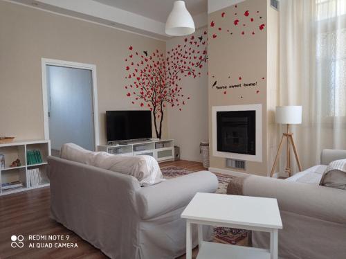 a living room with a white couch and a tv at Ginny's Room in Quartu SantʼElena