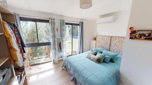 ein Schlafzimmer mit einem Bett und einem großen Fenster in der Unterkunft Balaruc-les-Bains - Villa 5 étoiles vue sur la lagune - Piscine et Jacuzzi ! in Balaruc-les-Bains
