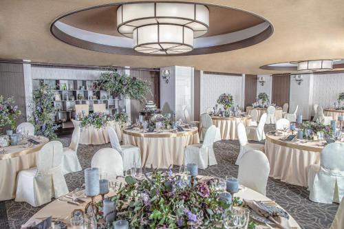 a banquet hall with tables and white chairs and flowers at ANA Crowne Plaza Fukuoka by IHG in Fukuoka