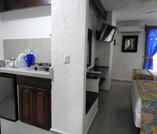 una pequeña cocina con fregadero y fogones en una habitación en Eco-hotel El Rey del Caribe, en Cancún