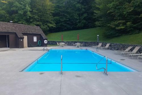 WaitsfieldにあるWaitsfield Condo with Pool and On-Site Trail Access!の大きな青いスイミングプール(椅子付)