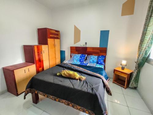 um quarto com uma cama e uma cabeceira em madeira em MOOKSQUARE GJ SPOT em Douala