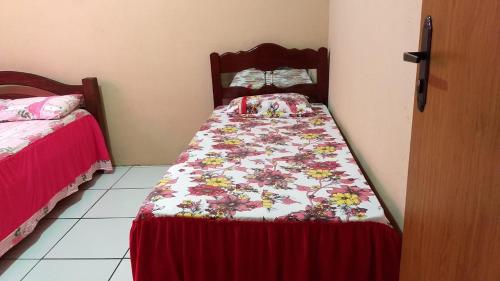 a bedroom with a bed with a flowered quilt at Vivenda Malu in Luis Correia