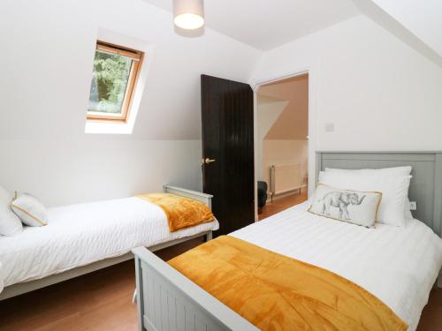 a bedroom with two beds and a window at Hayloft in Peterhead