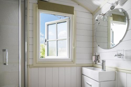 a bathroom with a sink and a window at Romantic Shepherds Hut, Kenilworth in Kenilworth