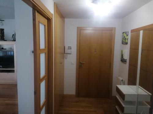 einen Flur mit Holztür und Treppe in einem Zimmer in der Unterkunft Apartamento Praga in Vitoria-Gasteiz