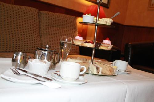 a table with cakes and cups and desserts on it at Best Western Ipswich Hotel in Ipswich
