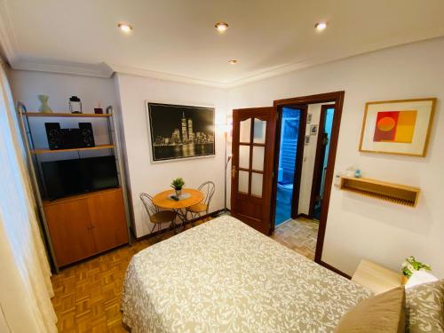 1 dormitorio con cama, mesa y TV en Sleeping Gran Via, en Madrid