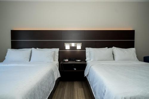 two beds sitting next to each other in a hotel room at Holiday Inn Express & Suites Deer Park by IHG in Deer Park