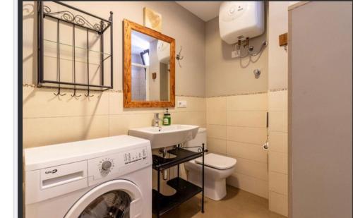een badkamer met een wasmachine en een wastafel bij Apartamento en Playa del Ingles CC Yumbo in Maspalomas