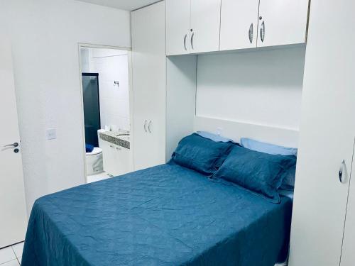 a bedroom with a blue bed and white cabinets at Quarto e sala com piscina próximo à praia in Maceió