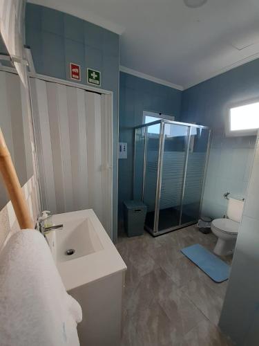 a bathroom with a sink and a shower and a toilet at Cantinho do Sonho in Maia