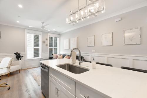 a white kitchen with a sink and a counter at The Palm Suite at 124 Spring in Charleston